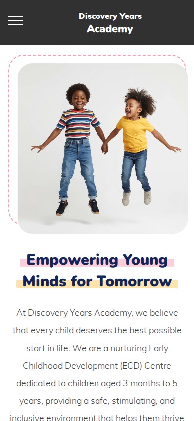 Discovery Years Academy homepage showing two children jumping beside a message about empowering young minds on mobile